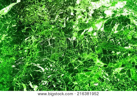Abstraction of the forest is a saturated light green color and a deep dark green color cut by white broken lines