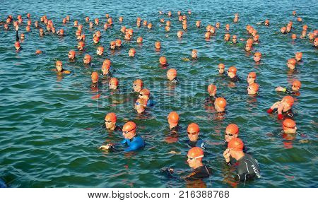GRAFHAM, CAMBRIDGESHIRE, ENGLAND - AUGUST 06, 2017:  Competitors waiting in water to start swimming stage of triathlon,