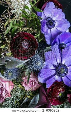 wedding, engagement, nature concept. marvelous bouquet of flowers for bride on the happiest day of her life, it is composed of bright lilac anemons, delicate buds of roses and maroon battercups