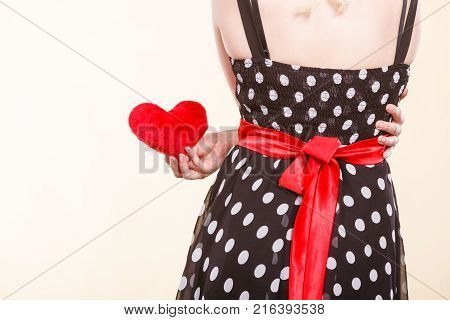Valentine day gift proof of love romantic present concept. Woman in retro polka dot dress holding small furry red heart