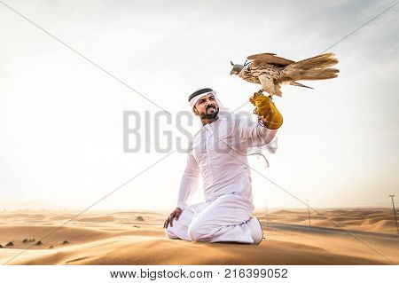 Arabian man walking in the desert at sunrise