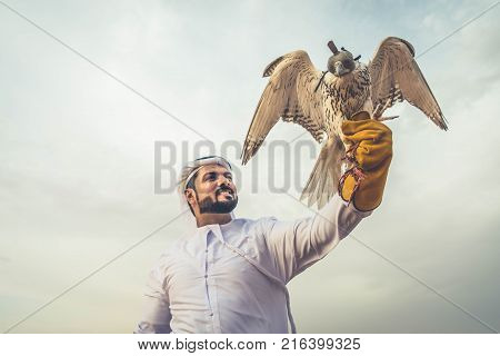 Arabian man walking in the desert at sunrise
