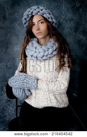 Winter fashion accessories.Young woman dressed for cold weather in grey snood hat and mittens.