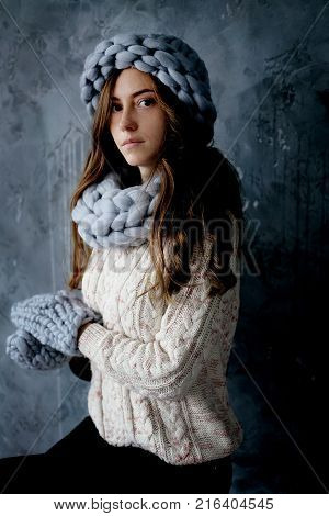 Winter fashion accessories.Young woman dressed for cold weather in grey snood hat and mittens.