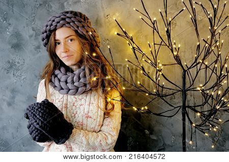 Winter fashion accessories.Young woman dressed for cold weather in grey snood hat and mittens.