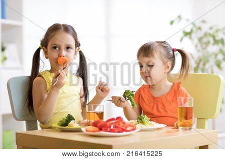 Little discontented children does not want to eat a pasta with vegetables