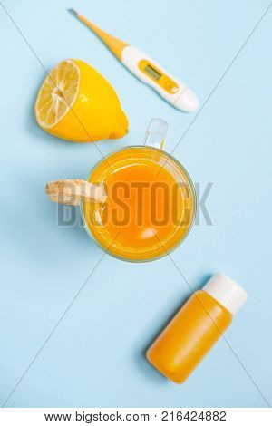 Ginger shot healthy drink with curd in a plastic bottle and thermometer on blue background. Immunity Boosting Tonic. Space for text