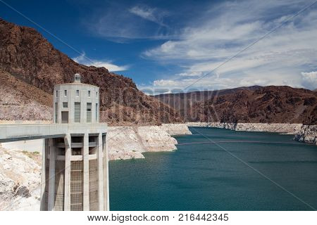 Hoover Dam Towers on the blue Lake Mead. Hoover Dam is a concrete arch-gravity dam in the Black Canyon of the Colorado River on the border between the U.S. states of Nevada and Arizona.