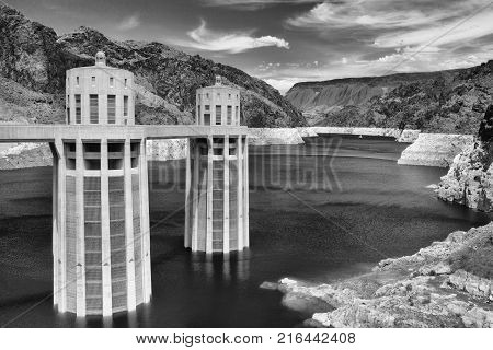 Hoover Dam Towers on the blue Lake Mead. Hoover Dam is a concrete arch-gravity dam in the Black Canyon of the Colorado River on the border between the U.S. states of Nevada and Arizona.