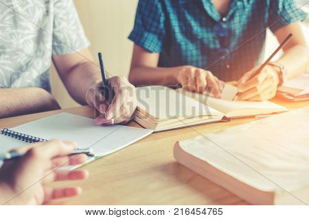 High School Or College Students Studying And Reading Together In Library