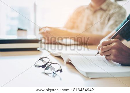 High School Or College Students Studying And Reading Together In Library