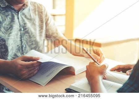 High School Or College Students Studying And Reading Together In Library