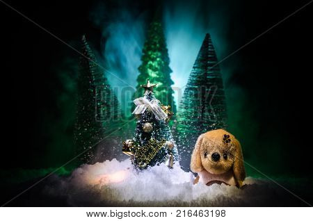 Toy Dog - A Symbol Of The New Year Under The Snow Against The Background Of Fir Branches. Toy's Dog 