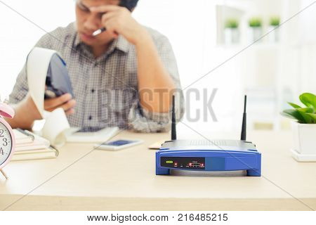 closeup of a wireless router and a man using machine on ofiice network lost