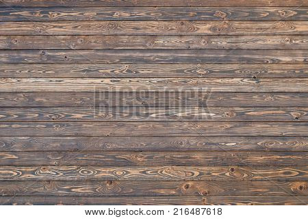 Background texture of dark brown faded horizontal wooden planks wall or floor, close up