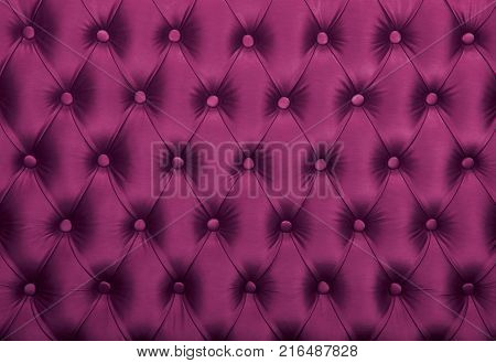 Purple capitone textile background, retro Chesterfield style checkered soft tufted fabric furniture diamond pattern decoration with buttons, close up