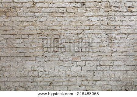 Wall of white and gray weathered limestone travertine stone brick blocks, close up background texture, side view