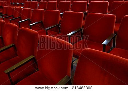 Close up red soft chair seats in a row, personal perspective, high angle view