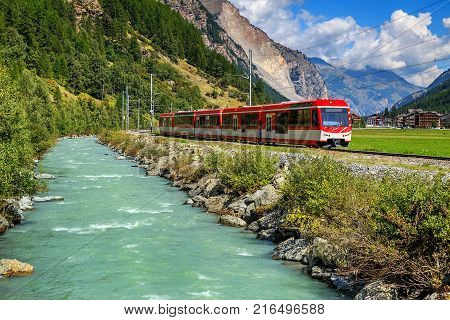 Famous electric red tourist train in Tasch, Valais region, Switzerland, Europe