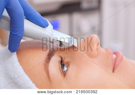 The Cosmetologist Makes The Procedure Microdermabrasion Of The Facial Skin Of A Beautiful, Young Wom