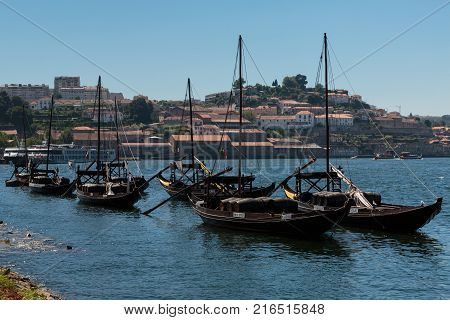 Oporto, Portugal - july 2016: Typical Rabelo Boats on the Bank of the Douro River and Vila Nova de Gaia in background - Porto Portugal