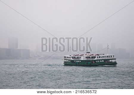 HONG KONG, CHINA - MARCH 2012 - Hong Kong's iconic Star Ferry makes its way across a smoggy and polluted Victoria Harbour.