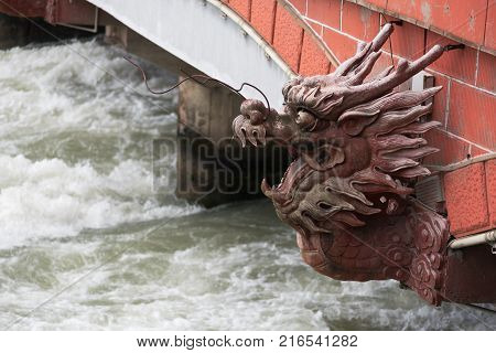 River flowing under a red bridge with a dragon head in Dujiangyan, China