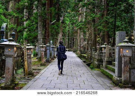 Wakayama Japan - Nov 24 2016. A man visiting Okunoin Cemetery on Mt. Koya in Wakayama Japan. Okunoin a mausoleum surrounded by an immense graveyard (the largest in Japan).