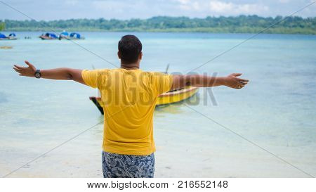 Guy on a beach with his arms open