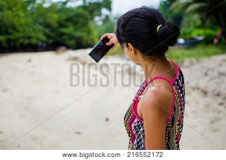 Girl Taking a Picture of Self on a Beach