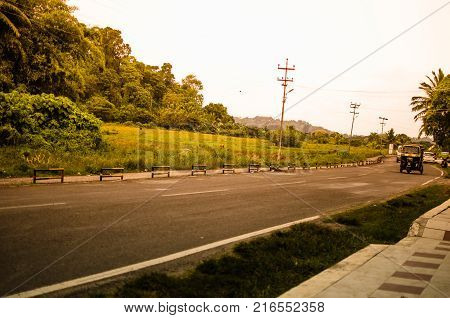 Road with Woods on one Side and greenery on other