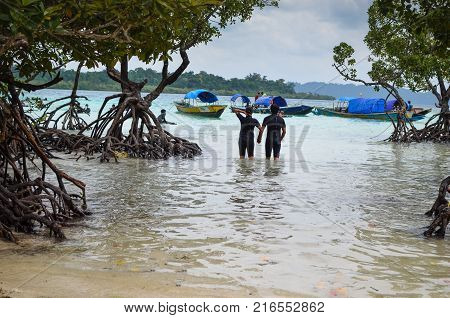 Couple Walking Through Mangrove holding Hands into the sea