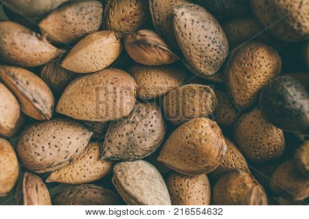 Shelled almonds as background. Close up view of shelled almonds texture and background for designers. Heap of almonds as background. Macro view of shelled almond. Almonds in their shells.