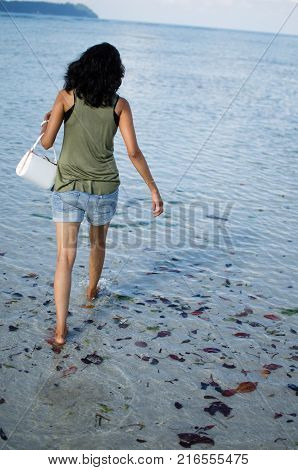 Girl Walking Angrily with her Bag on a Beach