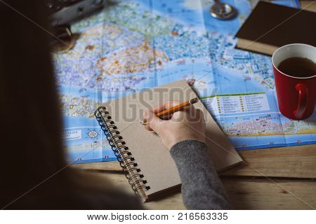 Travel Concept. Female Hand Marks The Spot On The Map. Top View