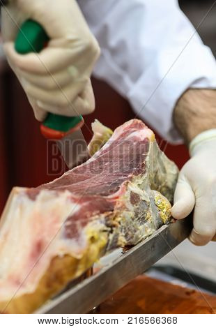 Cutting slices of cured iberian ham in Spain