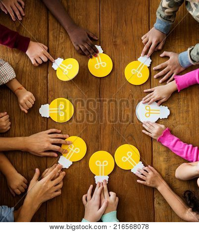 Group of children branstorming and sharing ideas with light bulb