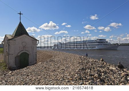 Goritsy, District of Kirillov, Vologda region, Russia - August 10, 2015: Passenger ship Maxim Litvinov passes near Goritsky Voskresensky monastery on the Sheksna River in Vologda Region
