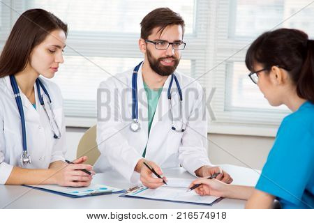 Group of doctors in the clinic discuss the diagnos of the patient