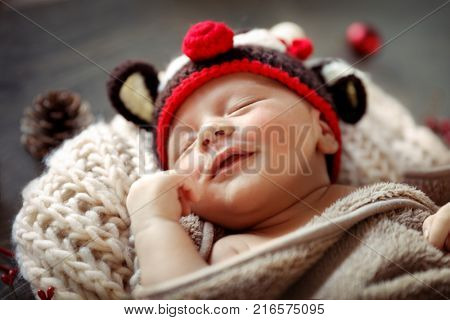Sweet baby boy sleeping at home in Christmas eve, wearing funny reindeer hat, Rudolph costume, happy Christmas time