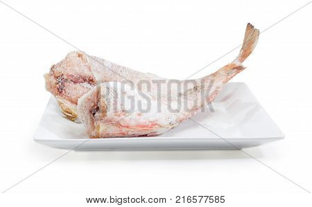 Two carcasses of the frozen red cod without heads on the large square white dish on a white background