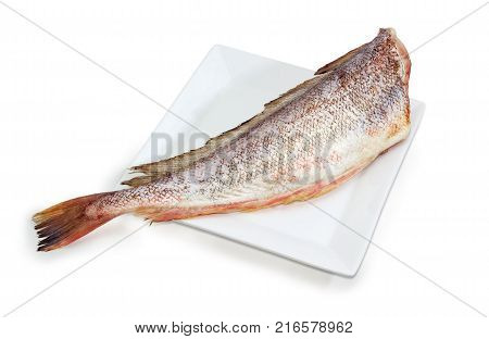 Carcass of the uncooked red cod without heads and purified from fish scale on the large square white dish on a white background