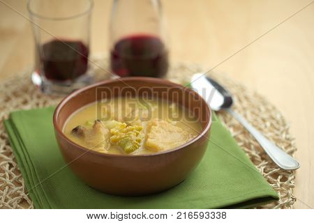 Cauliflower soup into cup, croutons of bread over tablecloth with spoon