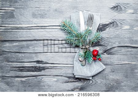Christmas table setting on bright wooden table. Christmas card with cutlery metal fork and knife on wooden table with copyspace