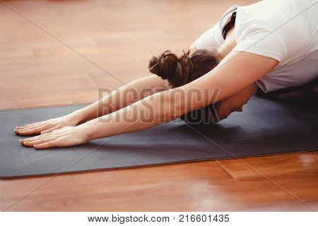 Yoga Concept. Close up woman meditates while practicing yoga in training hall or home.