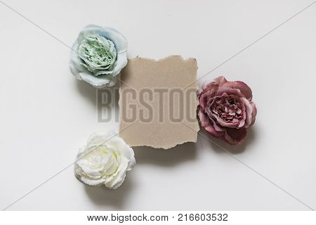 Piece Of Kraft Paper And Three Flowers Of Different Colors