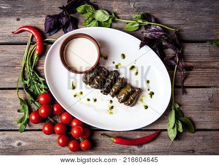 Cabbage rolls in grape leaves with sauce and tomatoes. Food a
