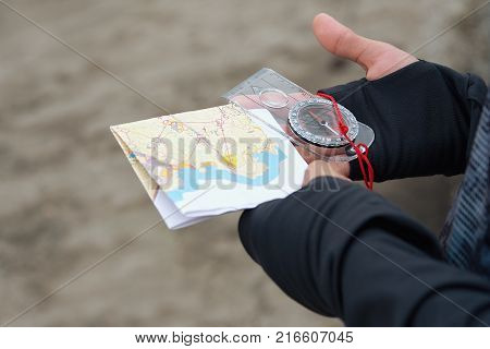 Man holding map.Athlete uses navigation equipment for orienteering,compass and topographic map