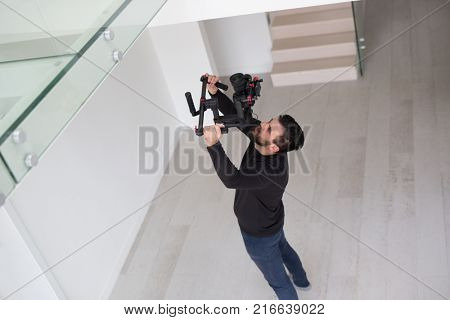 young videographer with gimball video slr at work