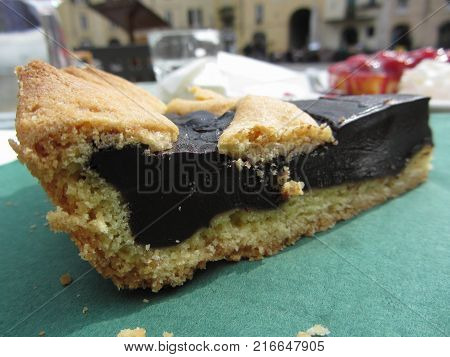 Piece of chocolate cake on green paper napkin . Typical cake from Lucca - Italy known as torta coi becchi